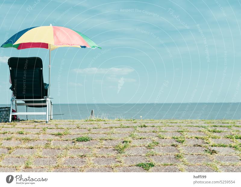 solitary folding chair with parasol and sea view - a Royalty Free