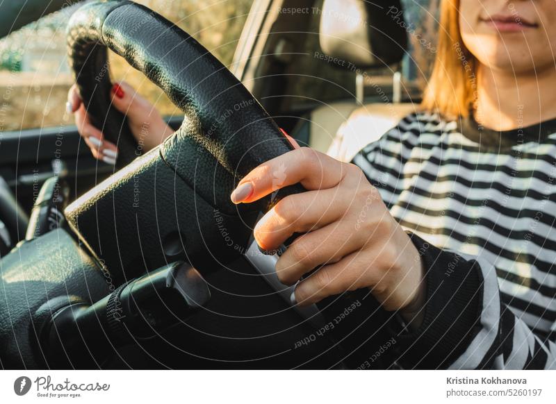 Female hands on black steering wheel of modern car. Automobile saloon. Woman driving on road. female vehicle woman automobile driver adult beautiful girl happy
