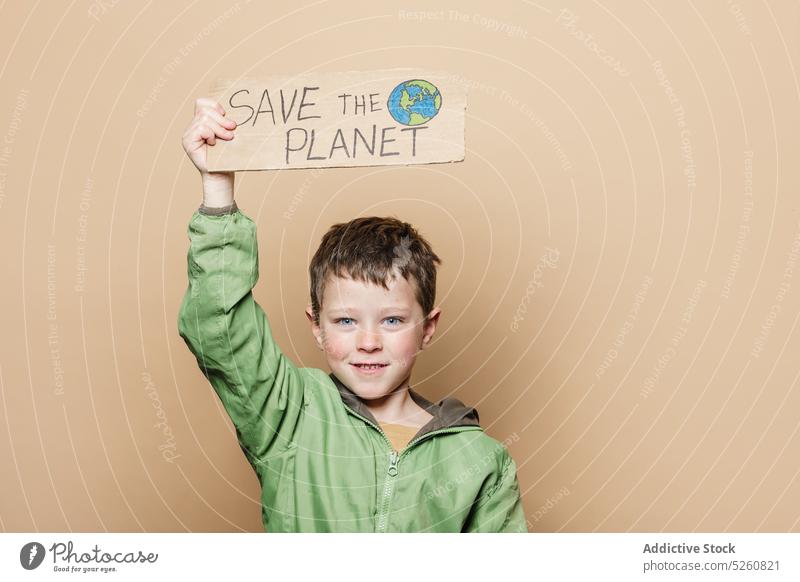 Boy with Save the Planet poster boy environment activist handmade carton save planet earth hand drawn child protest demonstrate ecology inscription placard