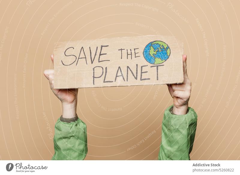 Crop child showing Save the Planet poster recycle planet environment inscription hand drawn globe world carton protest activist save kid arms raised placard