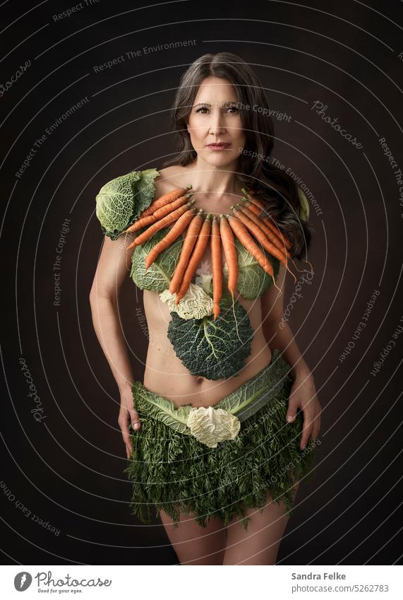A woman wears clothes that are made of vegetables. Vegetable carrots Savoy cabbage Vegetarian diet Nutrition Organic produce Healthy Healthy Eating Vegan diet