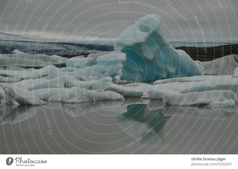 Iceberg with reflection in a glacier lagoon Icebergs Glacial melt Glacier ice Ice formations Climate change Blue White Gray freezing cold icy cold icily Cold