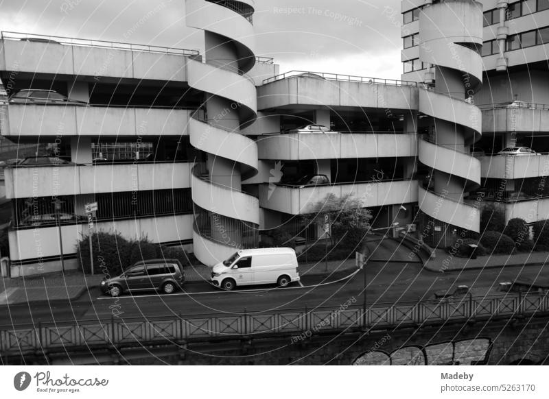 View from the Wuppertal suspension railroad of a parking garage made of gray concrete with spiral staircase in the Brutalism of the seventies in Wuppertal on the Wupper River in the Bergisches Land region of North Rhine-Westphalia, Germany