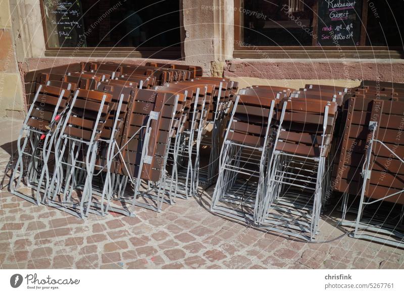 Folding chairs are leaning in sun in front of restaurant Chair Table Restaurant Gastronomy Seating Beer garden Sidewalk café Furniture Tourism Outdoor furniture