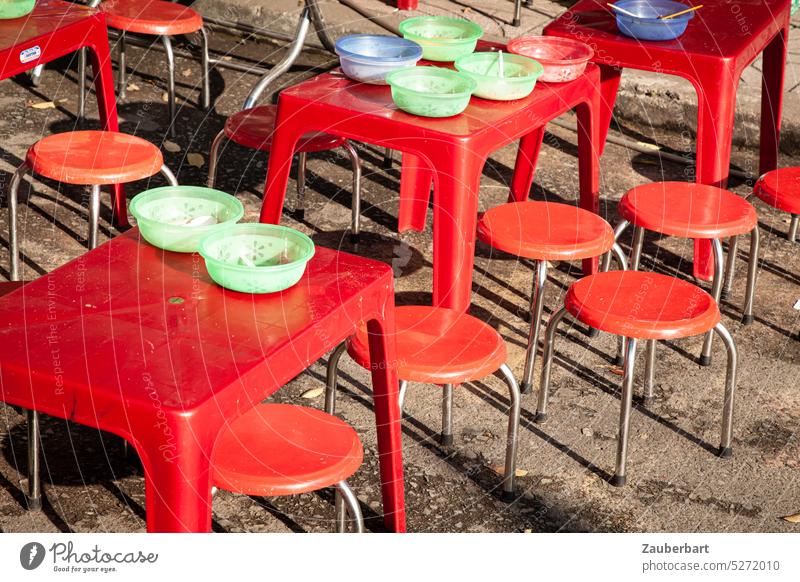 Red tables, red stools, on them colorful plastic bowls, form a group of round shapes Table Stool Round Sit Eating street food Vietnam Social in common