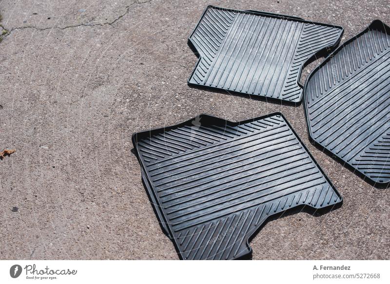 Three rubber floor car mats lying on the street ground. Car interior cleaning concept car interior Floor mat rubber mat Car wash Car wash service Washing