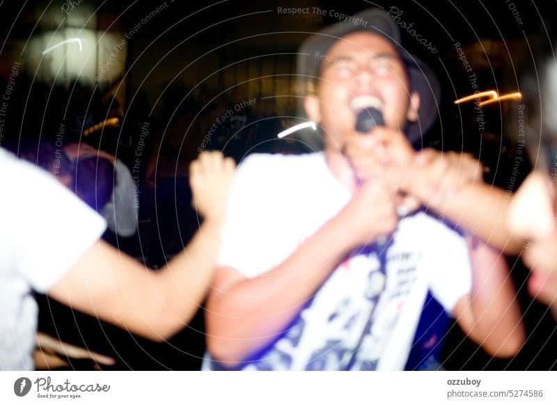 blurred of asian young man enjoying and sing along at hardcore/punk gigs show audience band cheering concert concert stage crowd dancing entertainment event