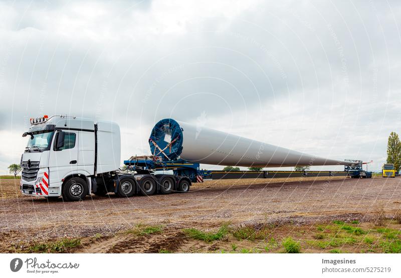 Truck in the field. Rotor blade for wind turbine. Special transport of a blade for a wind turbine on a special semi-trailer. lorry Field Wind energy plant