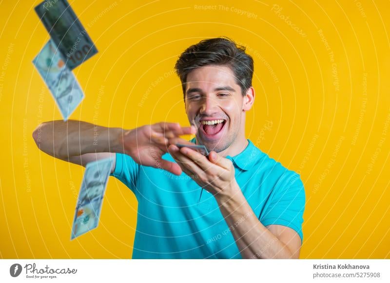 Man with a happy face scatters money. People overspend US currency. The man is flush with dollars on yellow studio background. finance success wealth cash video