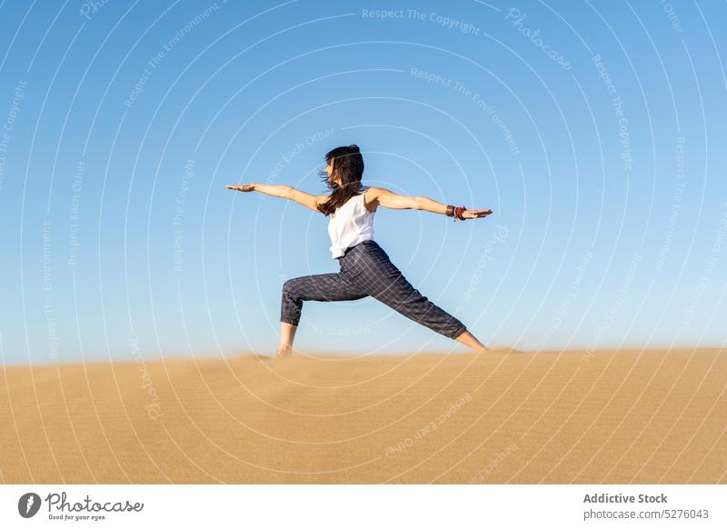 Slim woman standing on mat and doing Warrior I yoga in pose in daylight - a  Royalty Free Stock Photo from Photocase