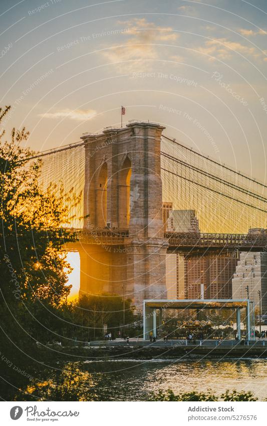 Picturesque view of famous suspension bridge brooklyn bridge river sunset cityscape urban architecture downtown construction modern building landmark evening