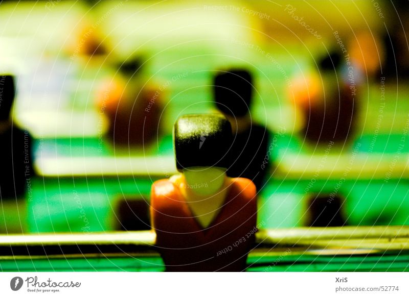 In the first row Table soccer Attacker Sports team Piece Shallow depth of field Colour photo Rod Green Row Behind one another Rear view Glittering