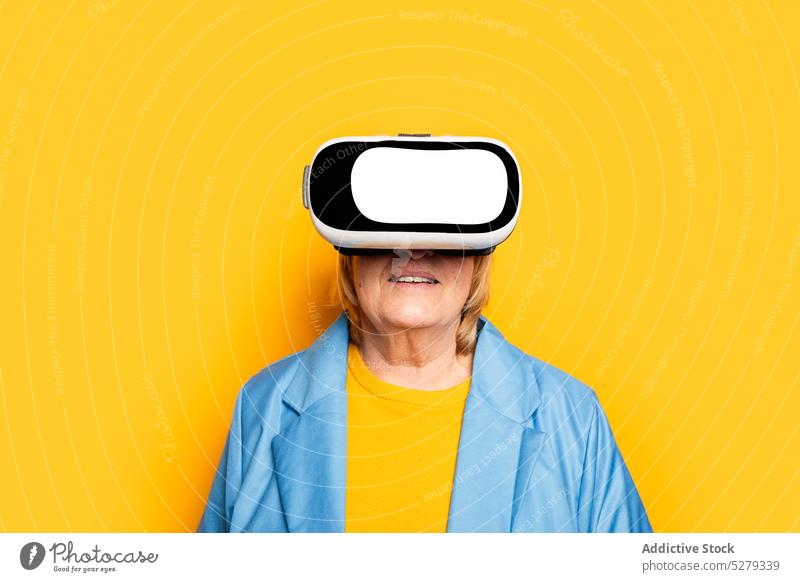 Stylish senior woman in VR headset vr goggles explore experience glasses cyberspace reality gadget elderly female virtual device futuristic using simulate