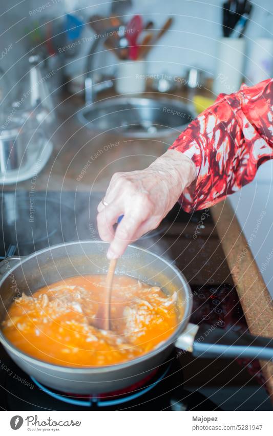 Senior woman cooking rice with chicken at home housewife cooking lunch home interior closeup hand hot preparation background ingredient kitchen aged woman