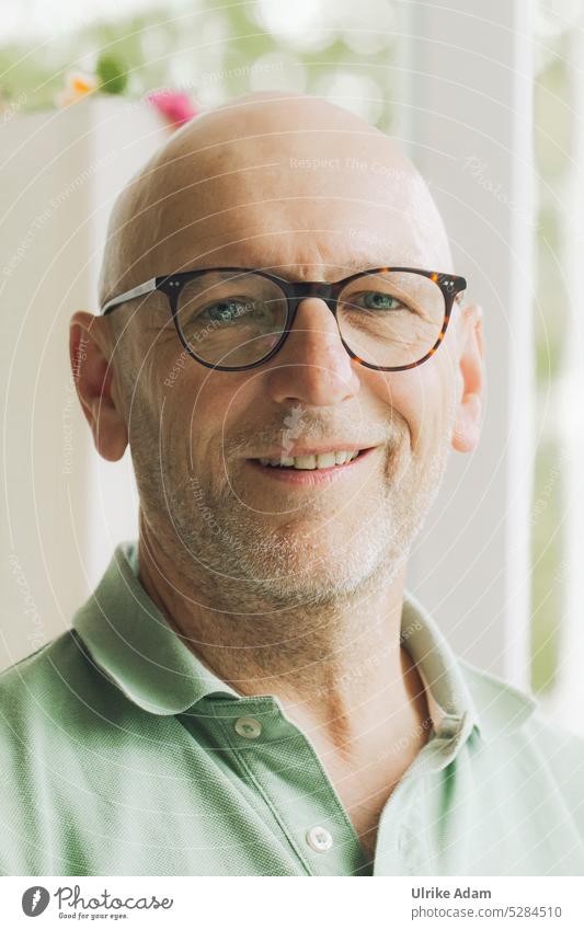 MainFux | Man with glasses and bald head looks mischievously into the camera Eyeglasses Human being Face portrait Adults Facial hair Head Smiling
