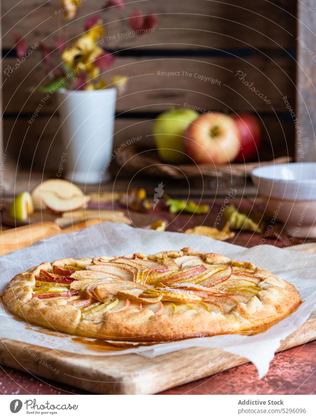 Freshly baked apple pie on baking paper autumn leaf shortcrust homemade cutting board pastry galette rolling pin delicious fresh recipe piece domestic kitchen