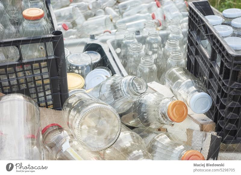 Various various types of empty glass bottles stored in containers for recycling, selective focus. dirty waste trash drink recycle used garbage industry