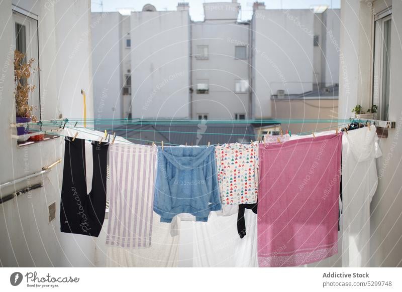 Drying linen on ropes between buildings air dry yard laundry town summer clean hang housework residential clothesline exterior sunlight wash street facade