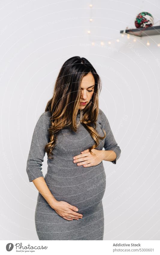 Calm pregnant woman touching baby bump - a Royalty Free Stock
