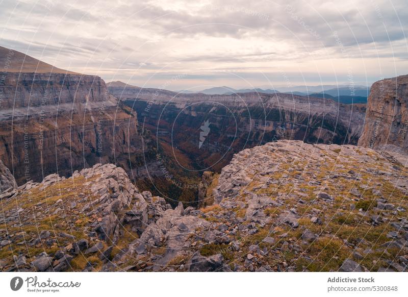 Rocky mountains under cloudy sky with sunlight rocky slope sunshine nature rough uneven countryside formation ordesa pyrenees of huesca spain europe wild