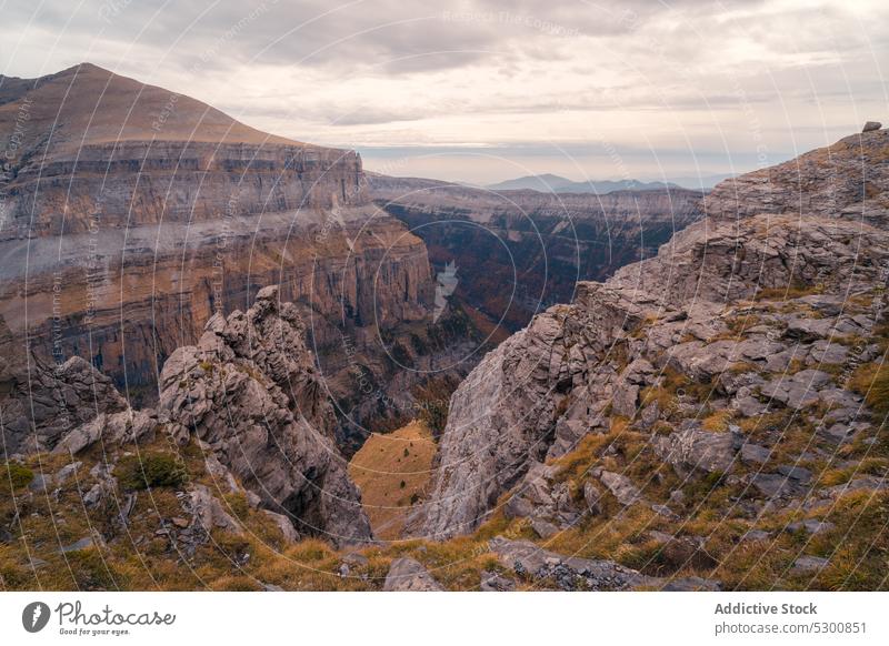 Rocky mountains under cloudy sky with sunlight rocky slope sunshine nature rough uneven countryside formation ordesa pyrenees of huesca spain europe wild