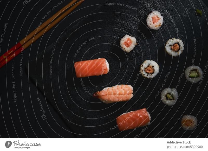 Delicious sushi rolls on board with chopsticks - a Royalty Free Stock Photo  from Photocase