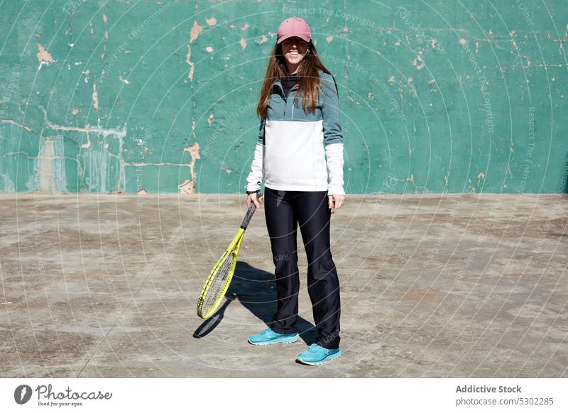 Sportive woman with tennis racket sportswoman smile player training wall female sportswear athlete positive happy cheerful young shabby cap activity vitality
