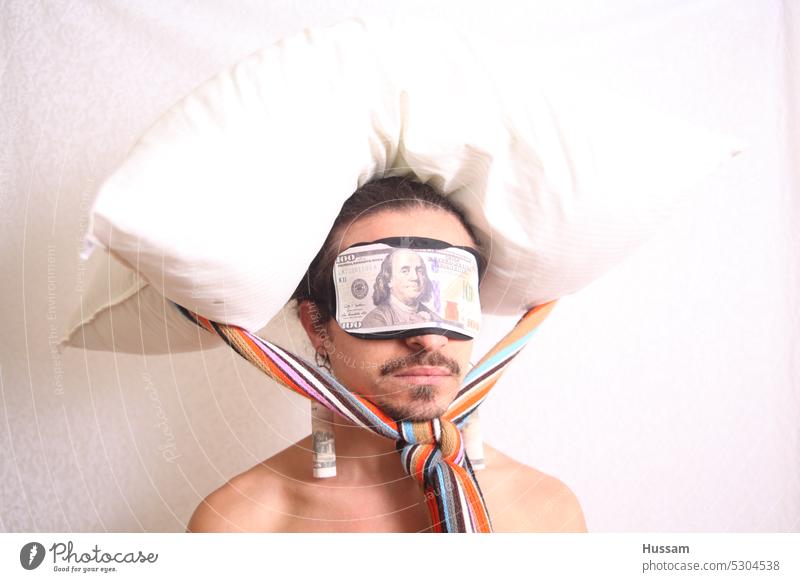 it is a photo concept a bout a person wearing a blindfold has dollar on it, and there is a pillow attached on his head. inflation Paying Financial Save savings
