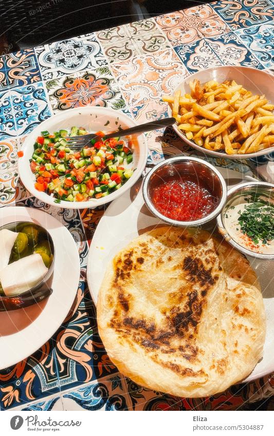 Various dishes on a table in the restaurant fries Essen Lettuce Malawach Malawah Restaurant Courts Food Eating Food photograph tablecloth variegated Nutrition