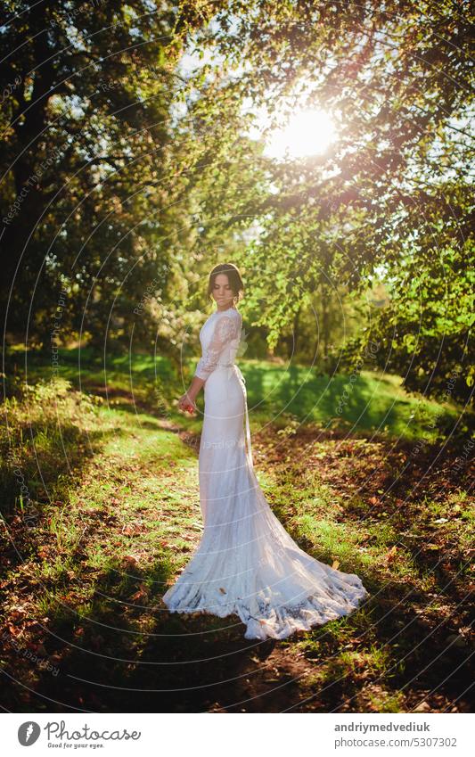 bride in wedding dress standing in woods park forest nature woman in white dress long white dress bride dress peaceful outdoor portrait sensuality romantic