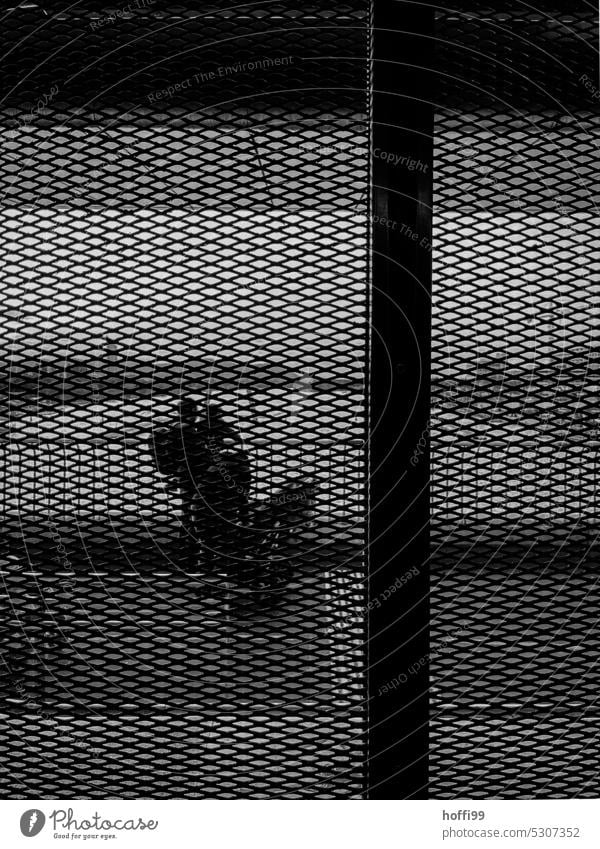 View through a grid on people Captured behind bars Shielded Grating Protection Fence Metal Barrier Border Bans Freedom Threat Safety Fear Dangerous