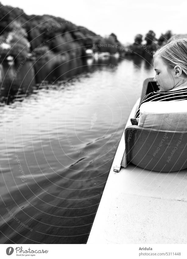 Girl sitting in pedal boat on a lake with shore and looking at the water b/w Lake Pedalo Child Water bank back view Head striped shirt Leisure and hobbies Trip