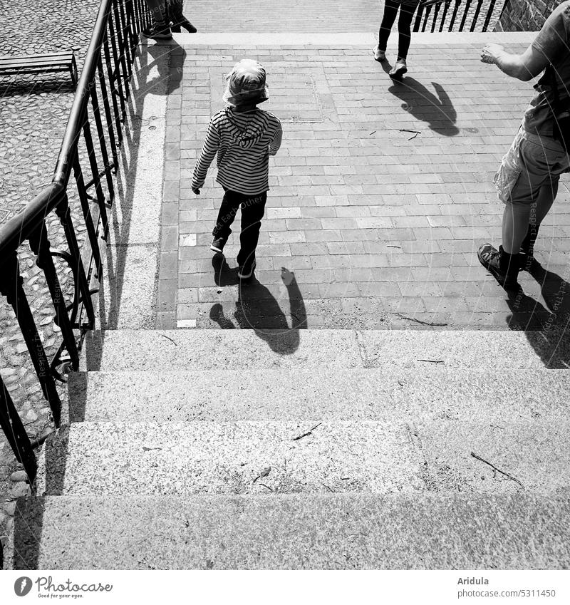 Big and small people walking down a wide staircase b/w children adult Family group Stairs stagger Stone Paving stone Walking Going stroll To go for a walk Trip