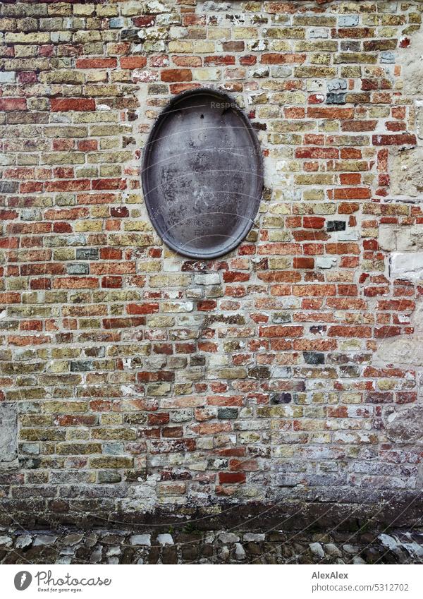 Very old, weathered brick wall with a faded oval gray headstone in the center Old very ancient Bricks Brick wall Wall (barrier) Wall (building) Facade