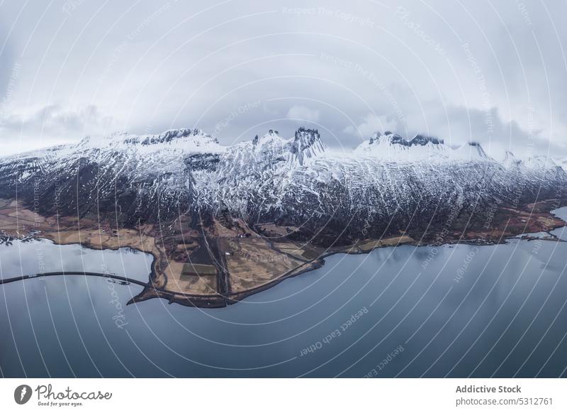 Snowy mountain ridge under cloudy sky iceland lake winter snow range landscape water cold nature pond picturesque season scenic weather highland breathtaking