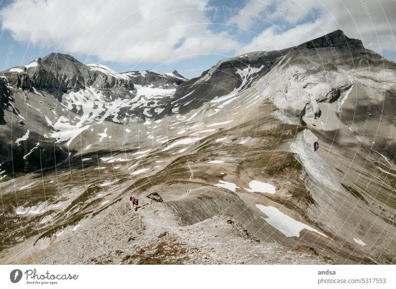 Group of people walking along a ridge in high mountains Mountain mountain massif hike Massive Landscape Cold Snow Exterior shot Nature Rock Wood grain