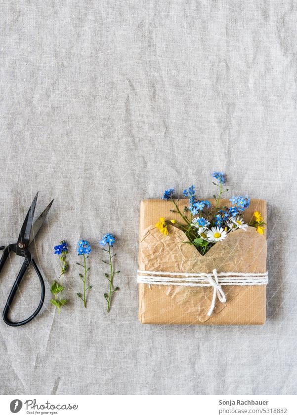 A gift wrapped in brown paper with fresh flowers Gift Packaged Sustainability Environment Birthday Heart-shaped Love Claw plastic-free Wrapping paper