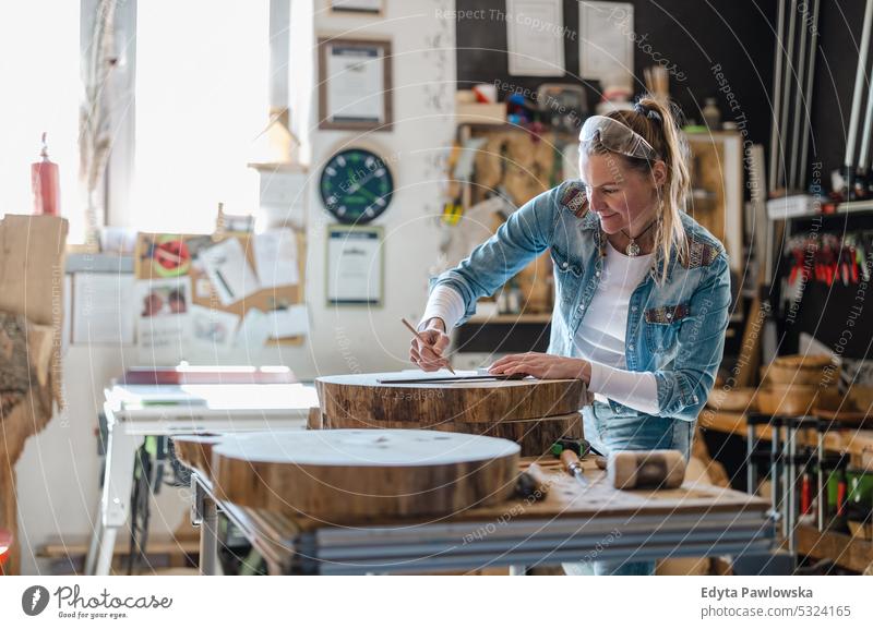 Craftswoman working with wood in a carpenter workshop real people wood workshop Carpenter Entrepreneur Competence Workshop Craftsperson Creativity Production