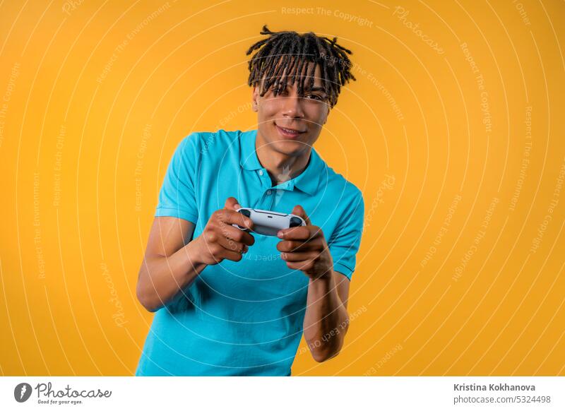 African teenager guy playing online video game, console TV with joystick.e-sport arrow button closeup computer control controller electronic enjoy entertainment