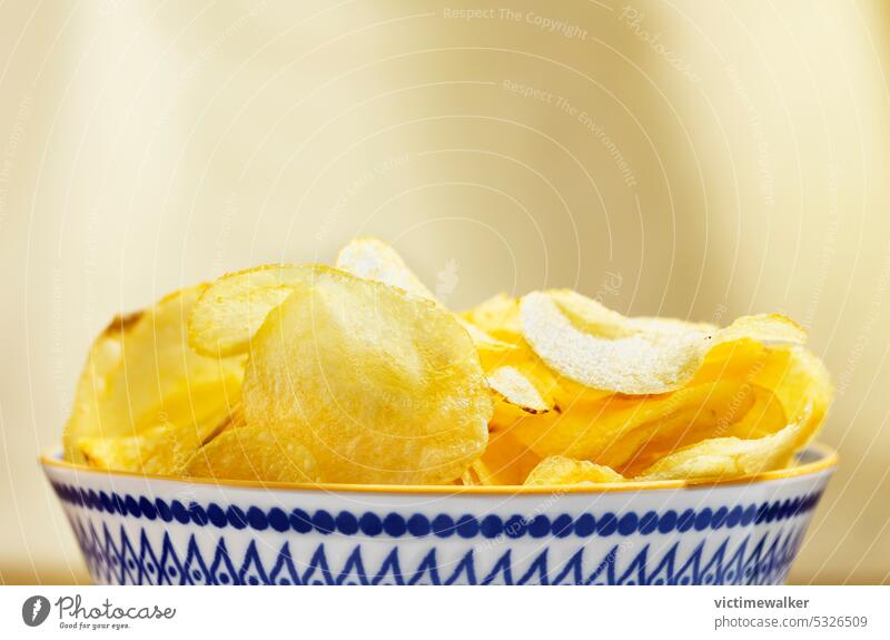 Bowl with potato chips studio shot food snack unhealthy eating tasty fried potato delicious yellow bowl front view out of focus background prepared potato