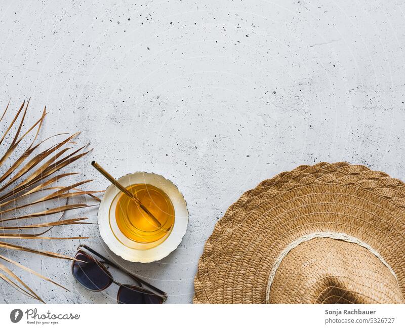 A sun hat, a cocktail and a palm leaf on a gray table. Flat lay. Rudbeckia Summer Cocktail Sunglasses Vacation & Travel Summer vacation Studio shot Design