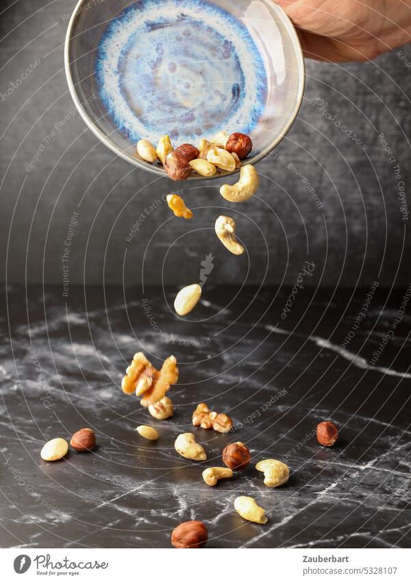 Nuts fall out of a ceramic bowl Pottery shell To fall Flying Trickle Still Life Do pottery Craft (trade) Creativity Arts and crafts Tone nuts almond hazelnuts