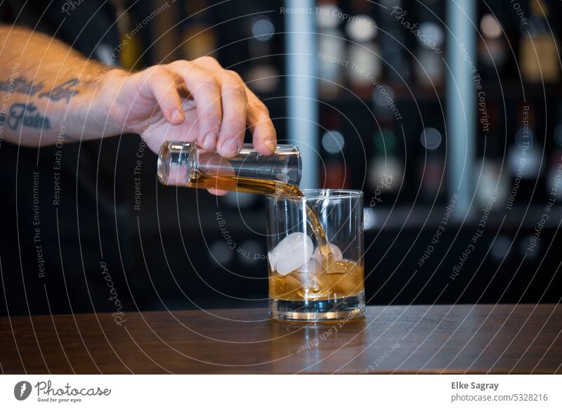 a scotch whiskey on the rocks is poured... Whiskey Glass Ice Cold Beverage Drinking Transparent Alcoholic drinks Dark Luxury arm Bar booze Bourbon Table cubes