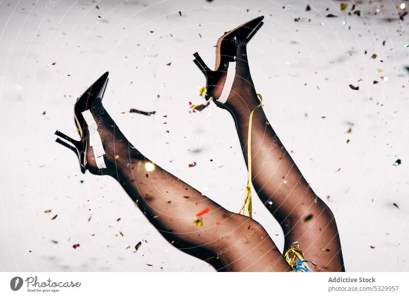 Crop woman in stylish shoes with confetti during party - a Royalty Free  Stock Photo from Photocase