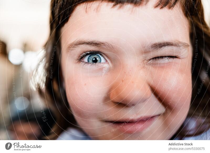 Cute girl winking at camera on blurred background smile portrait playful funny kid childhood cheerful happy cute preschool positive adorable freckle joy