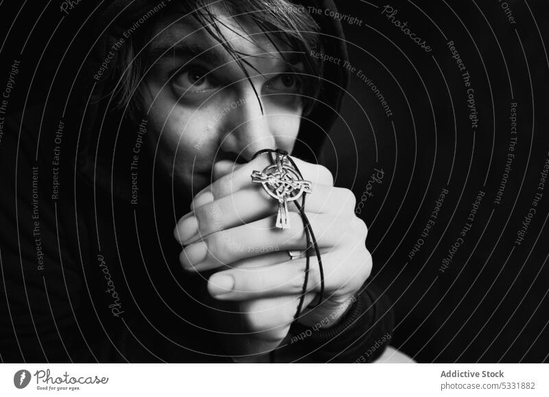 Young man praying in studio clasped hands religion hope symbol worship young god faith spiritual folded male calm tranquil serene peaceful casual guy wish