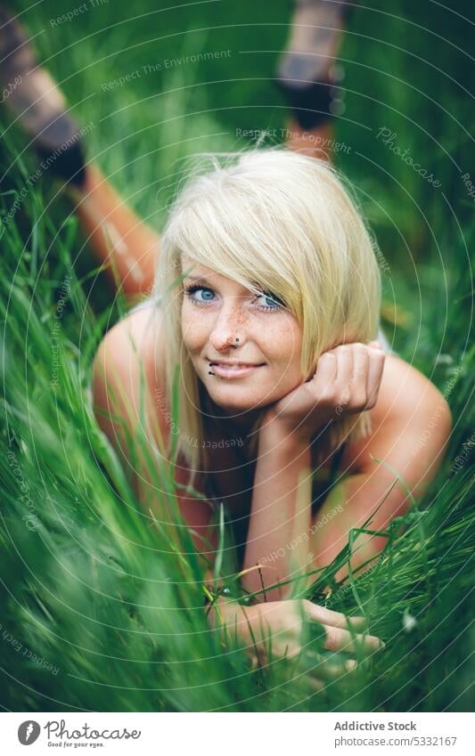 Cheerful woman lying in field grass young smiling green summer nature cute happy joy female beautiful freedom friendly lifestyle leisure rest blonde carefree