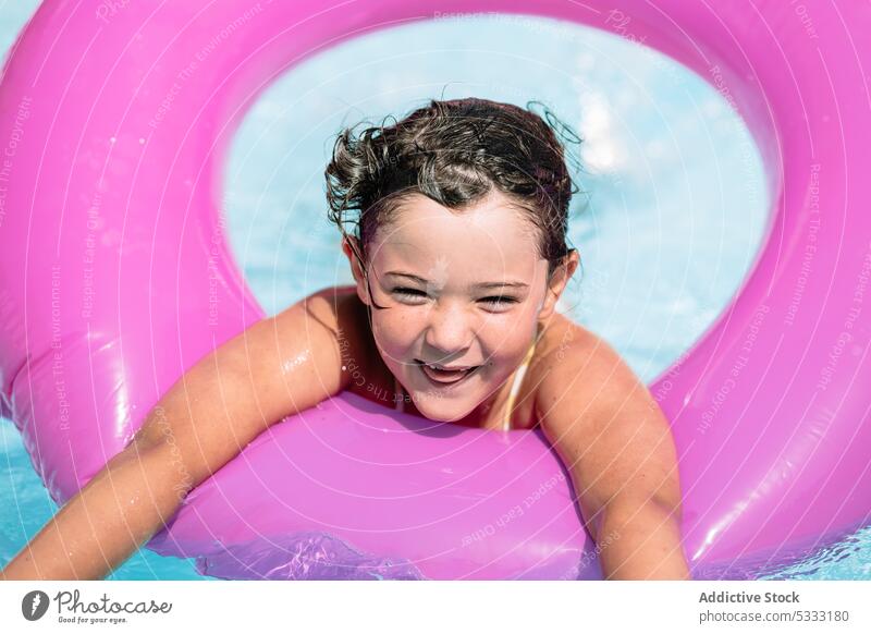 Cheerful girl swimming in pool kid child water enjoy smile rest cheerful inflatable happy vacation tube summer holiday ring childhood resort wet hair fun glad