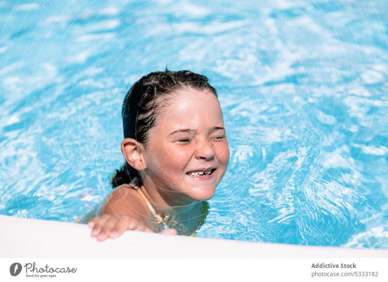 Happy kid with closed eyes swimming in pool girl smile child happy enjoy holiday cheerful summer vacation relax resort little rest water childhood female