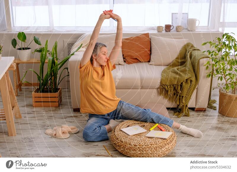 Adult woman meditating and enjoying life after surviving cancer yoga meditate practice recovery rehabilitation stretch sofa home survivor mindfulness exercise